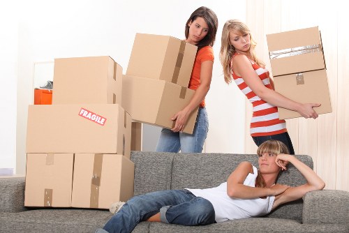 Professional movers carrying furniture during a house move in Falconwood